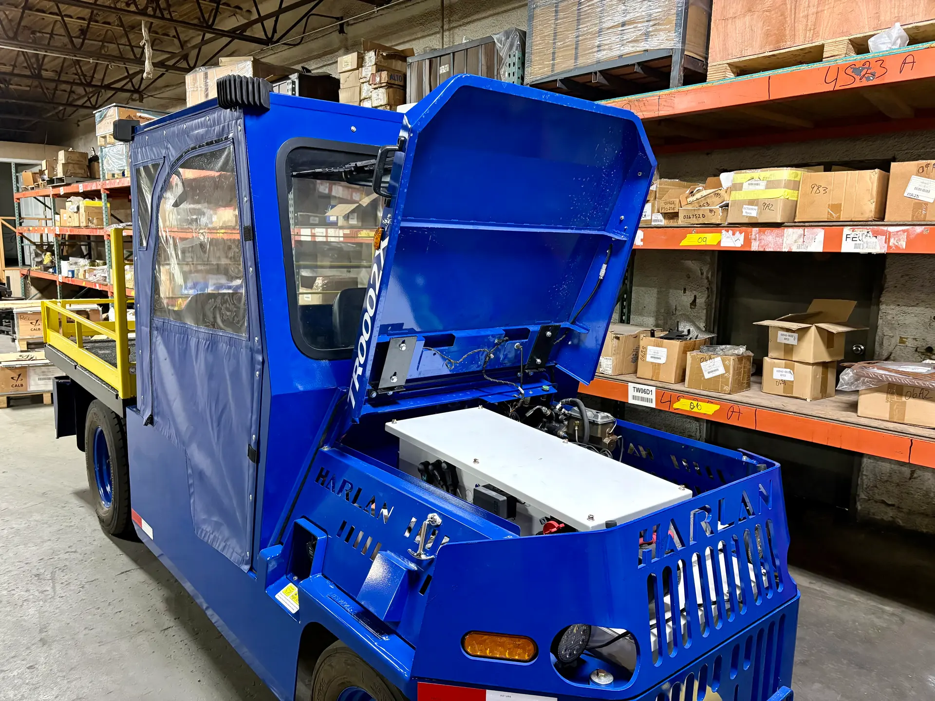 Electric ground support tractor with hood open during battery inspection