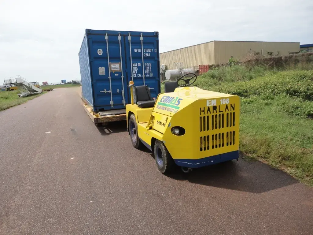 Yellow Harlan HT Classic tugging a blue shipping container