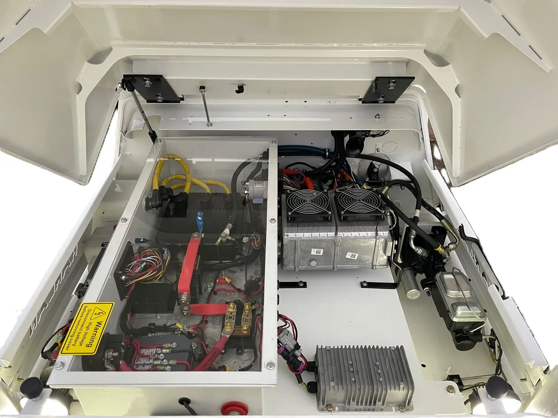 Hood of a white tractor propped open, showing the internal components of a lithium-electric model