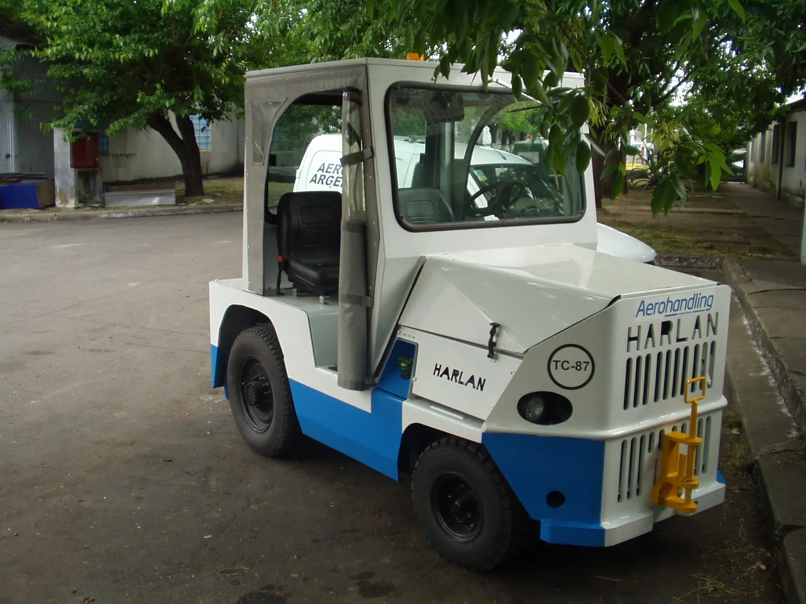 A white and blue Harlan aircraft pushback tractor utilized by Aerohandling in Argentina, demonstrating the global impact of specialized ground support equipment in South American aviation logistics.