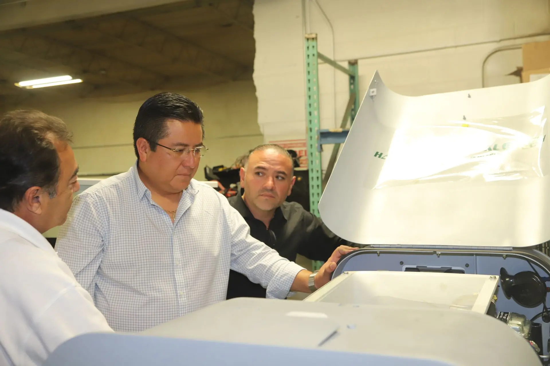 Technical representatives from Aero-Mexico performing a detailed inspection of a Harlan aircraft tractor engine at headquarters to ensure global operational safety.
