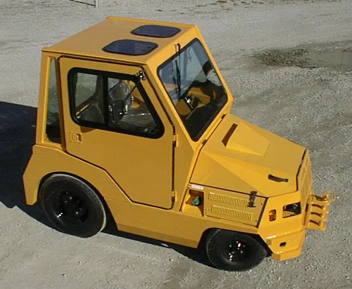 A yellow Harlan HLP50 tow tractor with a fully enclosed operator cab and skylights, showcasing a specialized build for high-visibility airport ground handling and industrial towing.